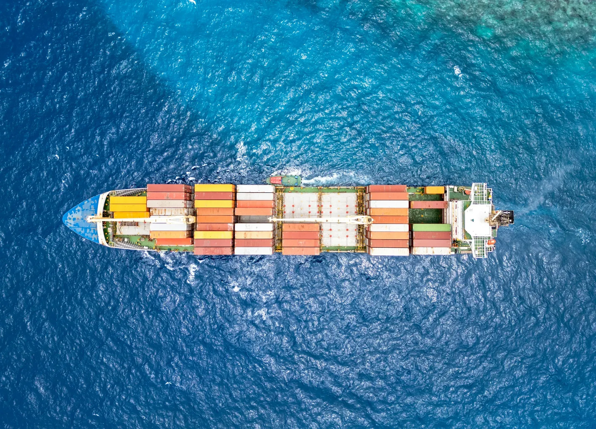 Aerial view of a container ship crossing deep blue ocean